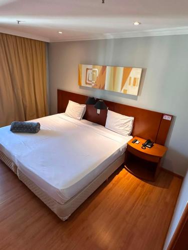 a bedroom with a bed with a remote control on it at Flat na Barra da Tijuca - Premium - Com Cozinha, Microondas, Estacionamento, Balsa para Praia, Academia, Muito lindo, Confortável e Aconchegante in Rio de Janeiro