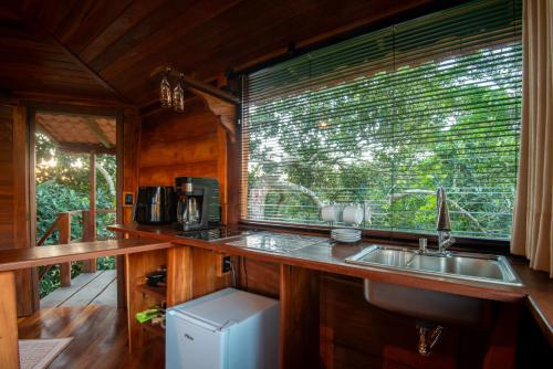 a kitchen with a sink and a window at Pousada Casa da Trilha in Vale do Capao