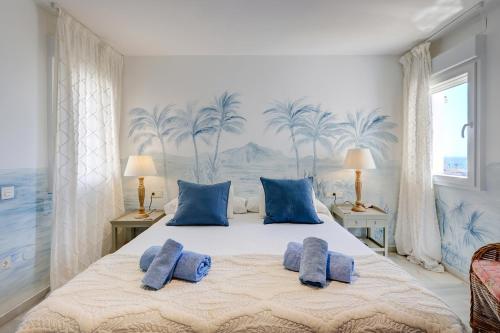 a bedroom with a large bed with blue pillows at Puerto Banus Harbour View Apartment in Marbella