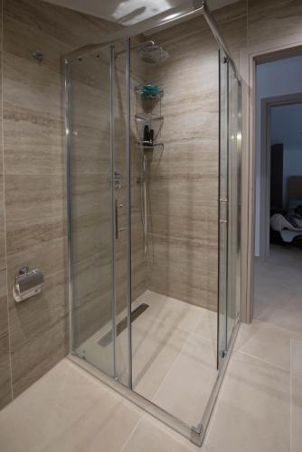 a shower stall in a room with wooden walls at Zeusplace Olympus Casa in Paralía Skotínis