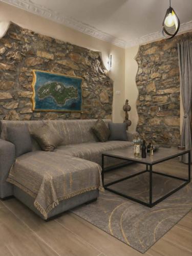a living room with a couch and a stone wall at George's Stonehouse in Samos