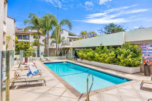 a swimming pool with lounge chairs next to a building at Beach Retreat in Santa Barbara