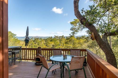 a deck with a table and chairs and a tree at The Silver Lady in Cambria