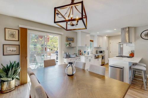 a kitchen and dining room with a large wooden table at Wanderlust Cambria Seaside Village in Cambria