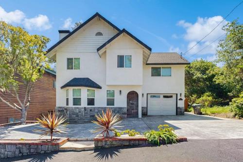 a large white house with a driveway at Wanderlust Cambria Seaside Village in Cambria