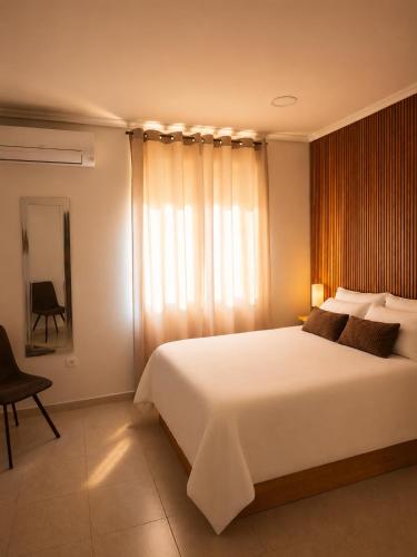 a bedroom with a large white bed and a window at Apartamentos Joli in Olivares de Duero