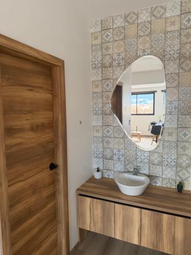 a bathroom with a sink and a mirror at Suite Vlady in Cuenca