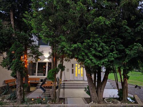 a house with a bench and trees in front of it at Riverstone Retreat in Jajce