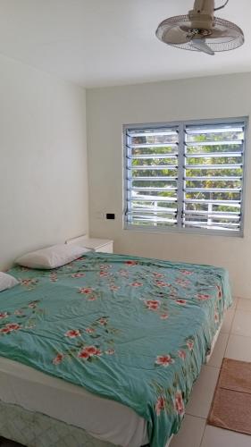 a bedroom with a bed with a green comforter at Sunview in Savusavu