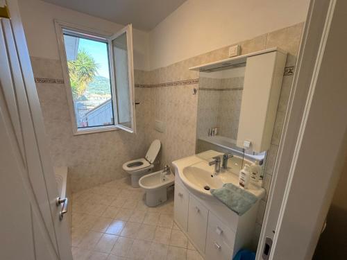a bathroom with a sink and a toilet and a window at Appartamento ad Andora a soli 5' dal mare in Laigueglia