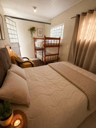 a bedroom with a large bed and a crib at Farol House in Pântano Grande