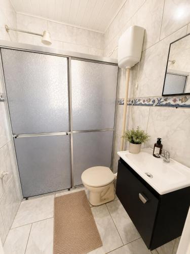 a bathroom with a shower with a toilet and a sink at Farol House in Pântano Grande