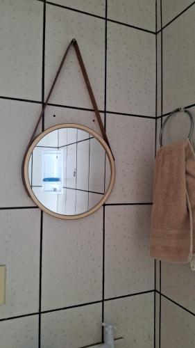 a mirror hanging on a wall in a bathroom at Casarão no centro de viçosa in Viçosa do Ceará