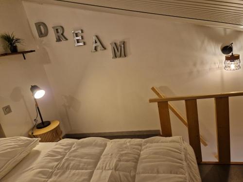 a bedroom with a bed and a sign that reads dream at Maisonnette à 350m de la plage in Berck-sur-Mer