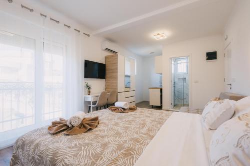 a bedroom with a large bed with towels on it at Dëshira Apartments in Ulcinj