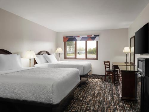a hotel room with two beds and a window at Avalon Hotel & Conference Center in Chippewa Falls