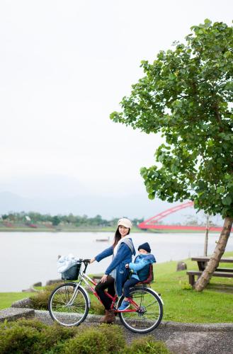 Una donna e un bambino in bicicletta vicino all'acqua di Sunny Stream B & B a Wujie