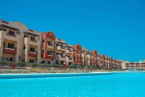 a row of apartment buildings next to a pool of water at لاسيرينا عيون موسى LaSerinaللعائلات in Ras Sedr