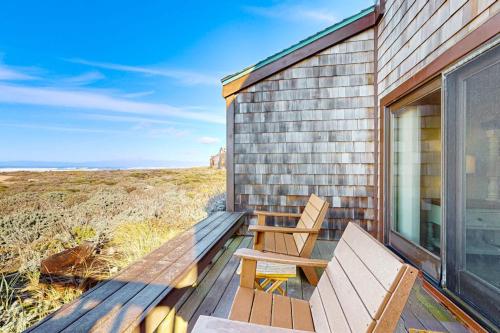 a wooden deck with a bench and a table at Monterey Dune Dream in Moss Landing