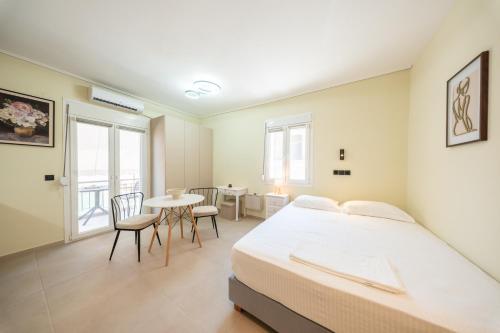 a bedroom with a bed and a table and chairs at Modern Studios for Two in Mytilene
