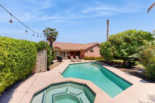 a swimming pool in front of a house at Evening Star in Indian Wells