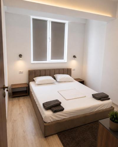 a bedroom with a bed with two towels on it at Rion Apartments in Saturn