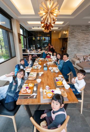 Eine Gruppe Kinder sitzt an einem langen Tisch in einem Restaurant in der Unterkunft Sunny Stream B & B in Wujie
