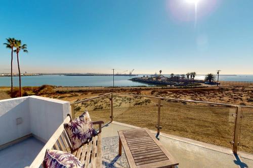 a bench on a balcony looking at the beach at Gull Cottage in Seal Beach