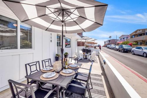 a table and chairs with an umbrella on a patio at Newport Coastal Charm in Newport Beach