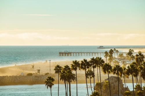 a view of a beach with palm trees and a pier at Relaxation Station in Corona del Mar