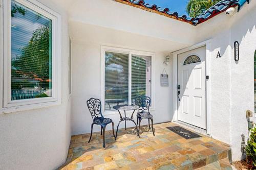 a porch with two chairs and a table and a window at Sunshine Fun Time in Newport Beach