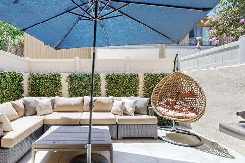 a patio with a couch and a blue umbrella at Mickey's Hideaway in Anaheim