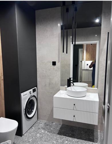 a bathroom with two sinks and a washing machine at Apartament z Tarasem Parking Smart TV Wi-Fi in Sosnowiec