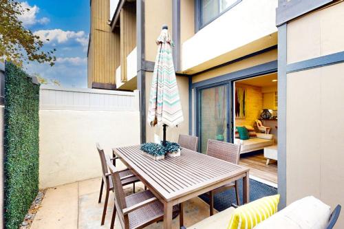 a wooden table with an umbrella on a patio at On the Doorstep in Anaheim