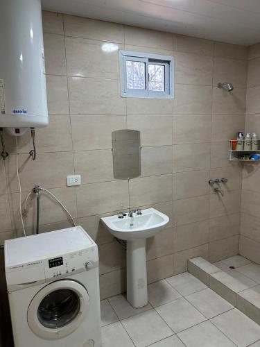 a bathroom with a washing machine and a sink at Finca Luz in Santiago del Estero
