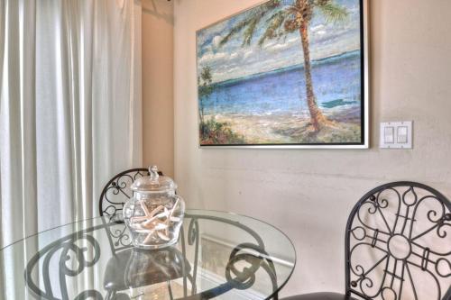 a glass table with two chairs and a vase on it at San Clemente - Monterey D in San Clemente