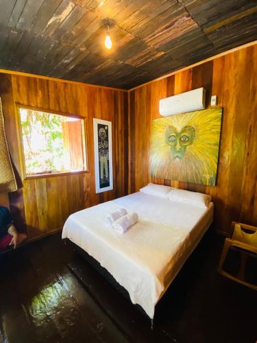 a bedroom with a bed with a painting on the wall at Casa Quietude - Manaus - Manacapuru in Manacapuru