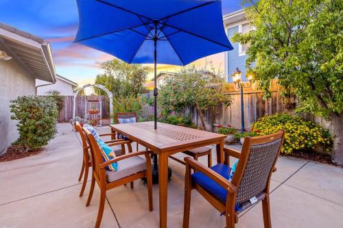 a wooden table with chairs and a blue umbrella at Berry House in Arroyo Grande