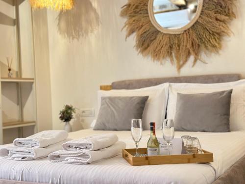 a bed with a tray of towels and wine glasses at Casa Palma Suites in Vlorë
