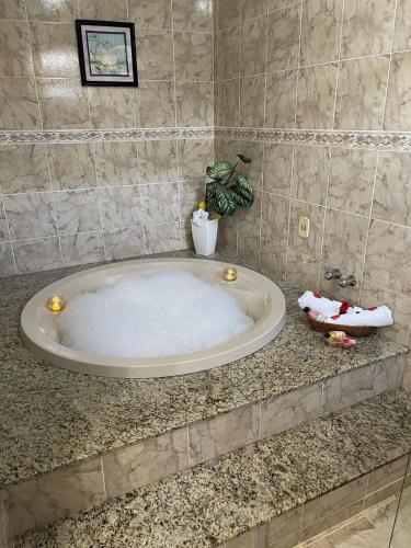 eine Badewanne auf einer Ablage in einem Badezimmer in der Unterkunft Pousada Flor D' Açucena in Natal