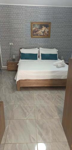 a bedroom with a large bed with blue pillows at Fatos in Pogradec