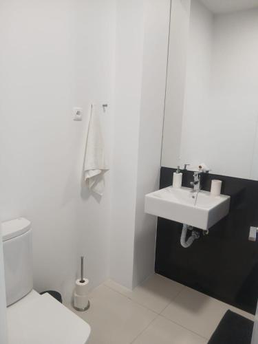 a white bathroom with a sink and a toilet at Casa das 3 Oliveiras in Porto Santo