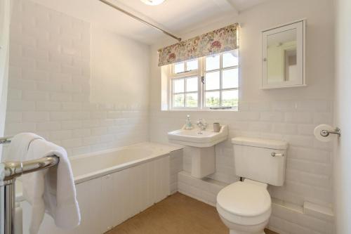 a white bathroom with a tub and a toilet and a sink at 3 Bed in Dunwich oc-atc2 in Dunwich