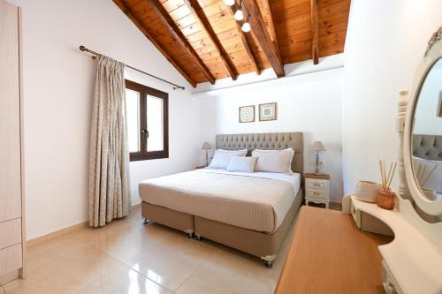 a bedroom with a bed and a mirror at Villa Emerald Diamond in Kolios