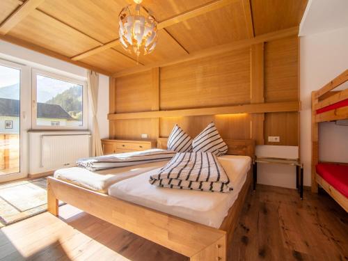 a bedroom with a large bed and a chandelier at Regenbogenhaus in Mayrhofen