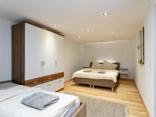 a bedroom with two beds and a dresser at Litzlhof Kraftplatzl in Itter
