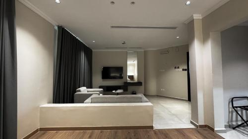 a living room with a bed and a television at Mirada Purple Najran Hotel in Najran