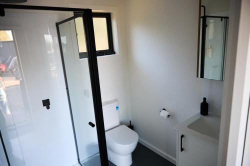 a bathroom with a toilet and a glass shower at Lake Colac Holiday Park in Colac