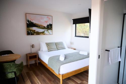 a small bedroom with a bed and a table at Lake Colac Holiday Park in Colac