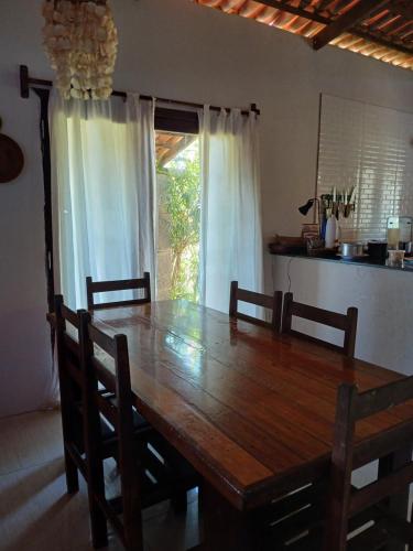 a wooden dining room table with chairs and a kitchen at Tigre Beach House in Trairi